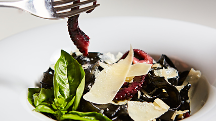 Image showing Pasta with black cuttlefish ink, octopuses and parmesan.