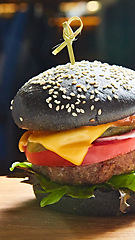 Image showing Japanese Black Burger with Cheese. Cheeseburger from Japan with black bun on dark background.