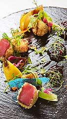 Image showing Close up of rare seared Ahi tuna slices with fresh vegetable salad on a plate.