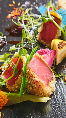 Image showing Close up of rare seared Ahi tuna slices with fresh vegetable salad on a plate.