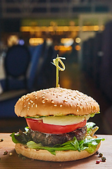 Image showing Beef burger with lettuce and mayonnaise served on a rustic wooden table of counter, with copy space.