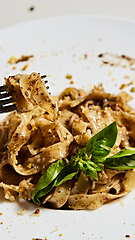 Image showing Tagliatelle with mushrooms and decorated with basil leaves.