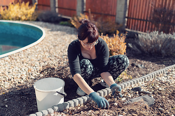 Image showing middle age woman gardener in spring garden