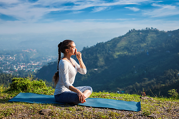 Image showing Woman practices pranayama in lotus pose outdoors