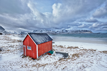 Image showing Red rorbu house shed on beach of fjord, Norway