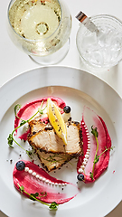 Image showing White fish with lemon on white plate, selective focus