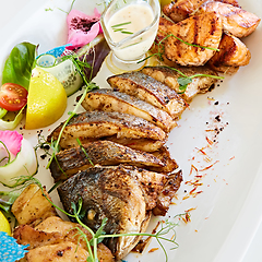 Image showing The fried fish on plate with vegetables. Shallow dof.