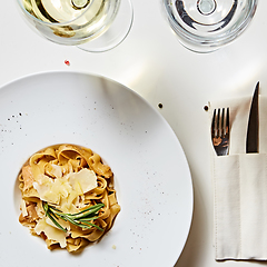 Image showing Close-up italian pasta plate with grated parmesan cheese and basil leaf