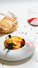 Image showing The cooked mussels and pasta with wine glass.