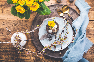 Image showing Easter table setting with spring flowers and cutlery on wooden table