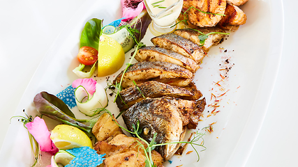 Image showing The fried fish on plate with vegetables. Shallow dof.