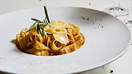 Image showing Close-up italian pasta plate with grated parmesan cheese and basil leaf