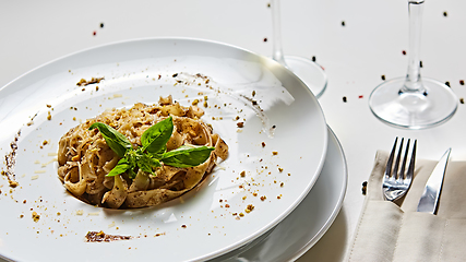 Image showing Tagliatelle with mushrooms and decorated with basil leaves.