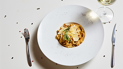 Image showing Close-up italian pasta plate with grated parmesan cheese and basil leaf