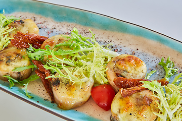 Image showing Fried scallops with butter lemon spicy sauce served with green salad. Top view, copy space.