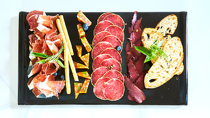 Image showing Antipasto Platter Cold meat plate with grissini breadsticks.