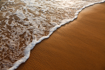 Image showing Wave surging on sand