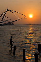 Image showing Fisherman and chinese fishnets on sunset. Kochi, Kerala, India