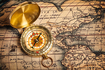 Image showing Old vintage golden compass on ancient map