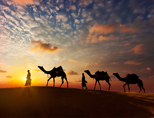 Image showing Two cameleers camel drivers with camels in dunes