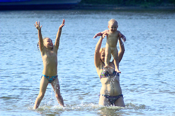 Image showing mother playing with her daughters at the river