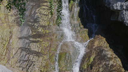 Image showing Big beautiful waterfall flows down the rocks mountains