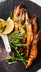 Image showing Grilled shrimp skewers. Seafood, shelfish. Shrimps Prawns skewers with herbs, garlic and lemon.