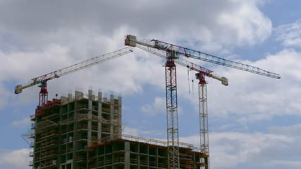 Image showing Tower cranes against blue sky, with clouds. Timelapse. UltraHD stock footage