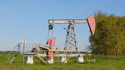 Image showing Operating oil and gas well in oil field, profiled against the blue sky