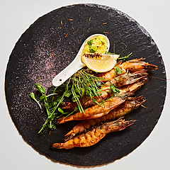 Image showing Grilled shrimp skewers. Seafood, shelfish. Shrimps Prawns skewers with herbs, garlic and lemon.