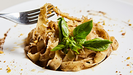 Image showing Tagliatelle with mushrooms and decorated with basil leaves.