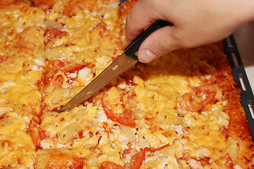 Image showing appetizing home pizza cutting by knife