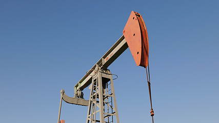 Image showing Operating oil and gas well in oil field, profiled against the blue sky