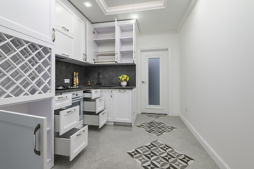 Image showing Open doors and drawers open at modern white kitchen