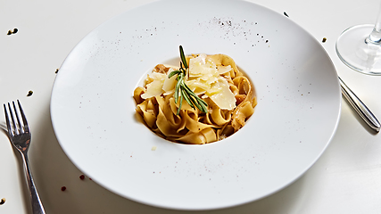 Image showing Close-up italian pasta plate with grated parmesan cheese and basil leaf