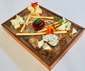 Image showing Cheese selection on wooden rustic board. Cheese platter with different cheeses on wood.