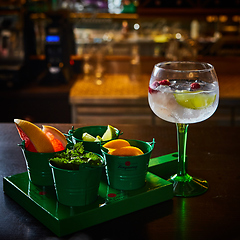 Image showing Raspberry Mojito Lemonade with lime and fresh mint in glass on wooden background.