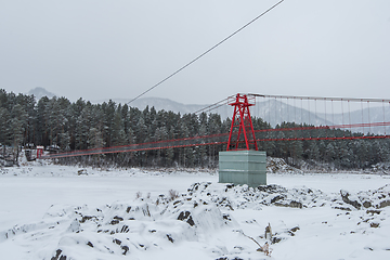 Image showing Suspension hanging bridge above winter frozen river