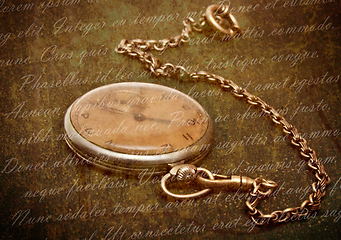 Image showing Old clock with chain lying on rough green surface