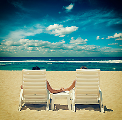 Image showing Couple in beach chairs holding hands near ocean