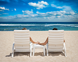 Image showing Couple in beach chairs holding hands near ocean