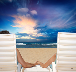 Image showing Couple in beach chairs holding hands near ocean