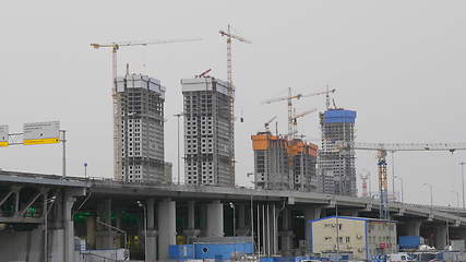 Image showing Many of cranes. Tower cranes against blue sky, with clouds.
