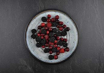 Image showing Berries with plate on shale