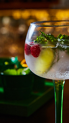 Image showing Raspberry Mojito Lemonade with lime and fresh mint in glass on wooden background.