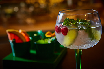 Image showing Raspberry Mojito Lemonade with lime and fresh mint in glass on wooden background.