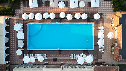 Image showing Aerial view on people in swimming pool. Top view of people sunbathing pool.