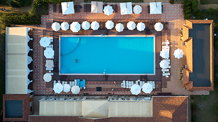 Image showing Aerial view on people in swimming pool. Top view of people sunbathing pool.