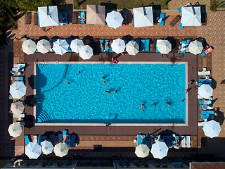 Image showing Aerial view on people in swimming pool. Top view of people sunbathing pool.