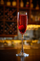 Image showing Red Cocktail in Champagne Glass near in the Bar with Amazing Blurred Background.